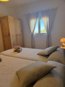 two beds in a bedroom with a window at Apartamentos La Fragata in Es Arenals