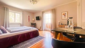a bedroom with a bed and a table and chairs at Kaiser's Landhaus in Schliersee