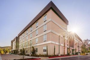 a large building with the sun shining behind it at Home2 Suites By Hilton Temecula in Temecula