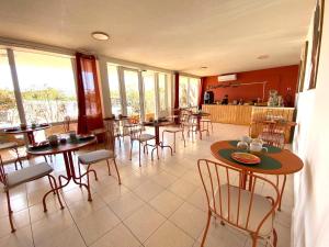 a restaurant with tables and chairs in a room at Hôtel Bellevue Cap d'Agde in Cap d'Agde