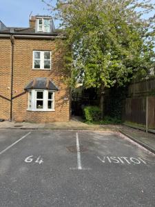 an empty street in front of a brick house at 64 Cressingham Road in London +6 photos