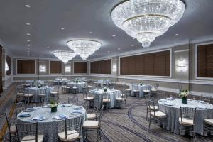 a banquet hall with tables and chairs and chandeliers at The Westin Mount Laurel in Mount Laurel