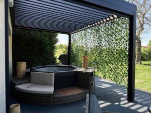 a patio with a hot tub under awning at Jacuzzi privatif Appartement premium Vendôme in Vendôme