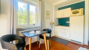 a small kitchen with a table and two chairs at Kaiser's Landhaus in Schliersee