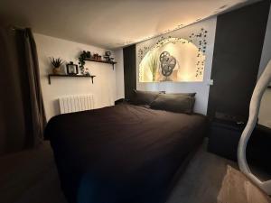 a bedroom with a black bed in a room at Jacuzzi privatif Appartement premium Vendôme in Vendôme
