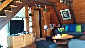 a living room with a couch and a tv at Ferienhaus Im Abendrot in Waldbrunn