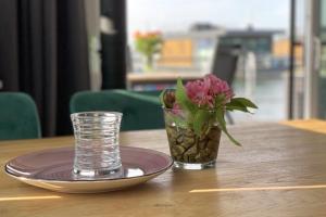 a vase of flowers sitting on a table with a plate at Floatinghouse Heaven on Earth in Klitten +18 photos