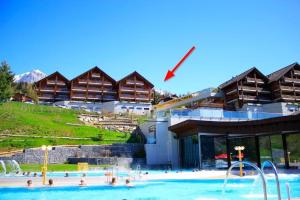 a swimming pool in front of a resort at Centre Thermal - Studio SUD avec grande terrasse in Ovronnaz