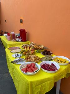 a table with plates of food on a yellow table cloth at Pousada Fonseca in Salinópolis