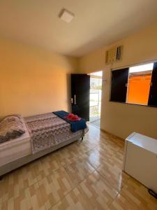 a bedroom with a bed and a wooden floor at Pousada Fonseca in Salinópolis