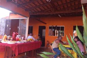 a group of people sitting at a table with food at Pousada Fonseca in Salinópolis