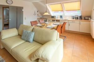a living room with a couch and a table at Exklusive Ferienwohnung Sonnenplatz 30 in Norddeich