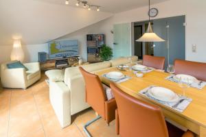 a dining room and living room with a table and chairs at Exklusive Ferienwohnung Sonnenplatz 30 in Norddeich