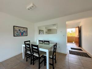 a dining room with a white table and chairs at Agua 22 in Mar de las Pampas