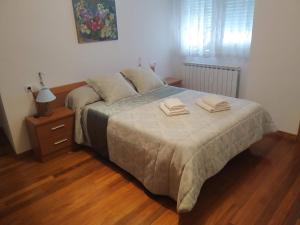 a bedroom with a bed with two towels on it at La Casa de Lines in Monforte de Lemos