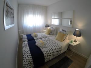 um pequeno quarto com uma cama branca e azul em Apartamento Da Lapa no Porto