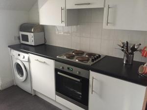 a kitchen with a stove and a microwave at Heaven Above the Haven in Millport