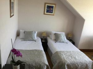 a room with two beds and a vase of flowers at Heaven Above the Haven in Millport