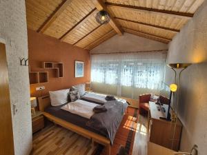 a bedroom with a bed and a desk and a window at Landhotel Schönblick in Bad Herrenalb