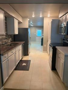 a kitchen with white cabinets and a tile floor at Woodrow St in Arlington