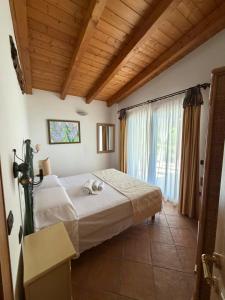 a bedroom with a bed and a large window at Villa Veronica in Sedini