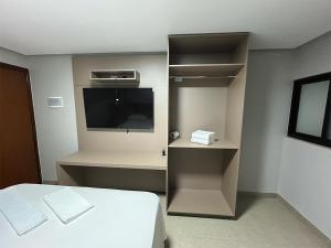 a bedroom with a bed and a flat screen tv at Mega Palace Hotel in Morrinhos