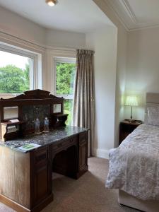 a bedroom with a desk and a bed and a window at Derryvree House in Maguires Bridge
