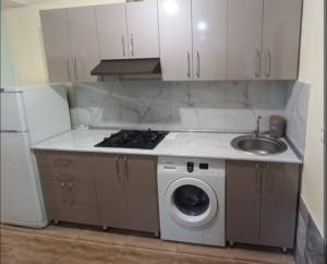 a kitchen with a washing machine and a sink at happy star stay in Sheki