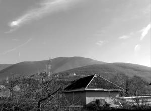 a black and white photo of a building with mountains in the background at happy star stay in Sheki +4 photos