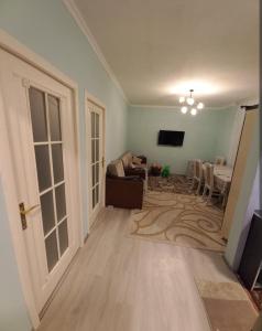 a living room with a couch and a television at happy star stay in Sheki