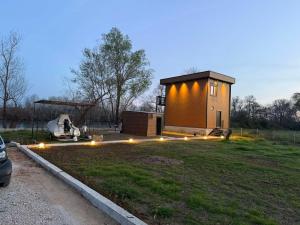 a small house with lights in a field at Hoota Cottage Bojana River in Ulcinj +5 photos
