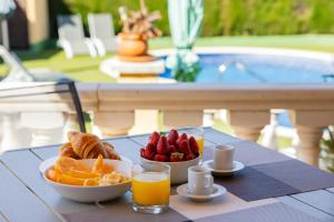 a table with a plate of fruit and orange juice at Casa L'Escala 31 in L'Escala