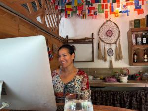 a woman sitting at a table with a laptop computer at Kawabonga in Palomino