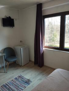 a bedroom with a bed and a window and a chair at Attico Viva - Self Check-in in Plitvička Jezera +44 photos