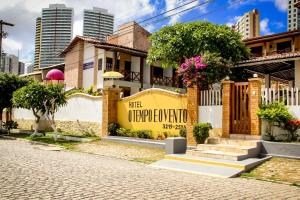 a building with a yellow sign on the side of it at O Tempo e o Vento in Natal