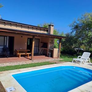 a swimming pool in front of a house at Cabañas Altos de San Blas 3 in Pueblito