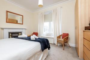 a bedroom with a bed and a window and a chair at Church View - Elie in Elie