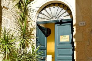 Una puerta azul en un edificio con un cartel. en B&B La Corte Lecce, en Lecce