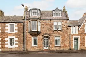 an old brick building with white windows at Church View - Elie in Elie