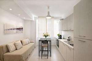a living room and kitchen with a couch and a table at Marchese 25 Apartments in Bari +63 photos
