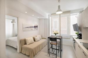 a living room with a couch and a bed and a table at Marchese 25 Apartments in Bari