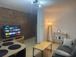 a living room with a couch and a flat screen tv at Departamento cercano al centro de Ezeiza in Ezeiza
