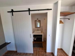 a door leading into a bathroom with a sink at Finca Mirador in Macastre