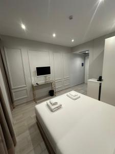 a bedroom with a white bed and a television at Ajsel Luxury Rooms in Sarandë