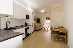 a kitchen and a living room with a table at Apartamentos Turísticos Penadés in Tomelloso +13 photos