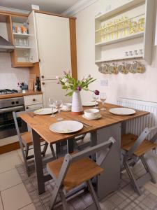 a kitchen with a wooden table with wine glasses at Little Lemon in Reydon