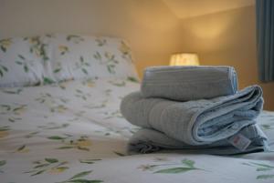 a stack of towels sitting on top of a bed at Little Lemon in Reydon