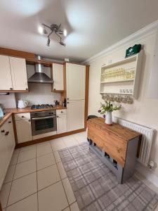 a kitchen with white cabinets and a wooden table at Little Lemon in Reydon
