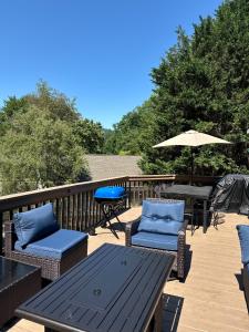 a deck with chairs and a table and an umbrella at Serenity Cove in Hiawassee
