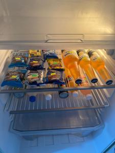 an open refrigerator filled with food and drinks at Departamento cercano al centro de Ezeiza in Ezeiza